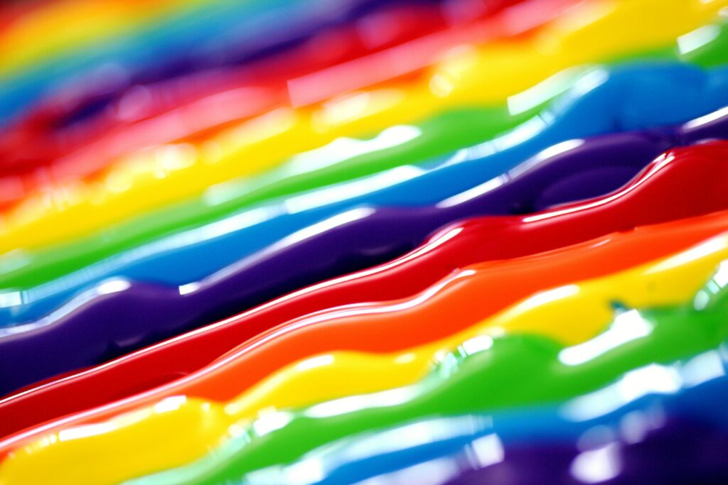 Colorful pieces of plastic are arranged to form a rainbow pattern